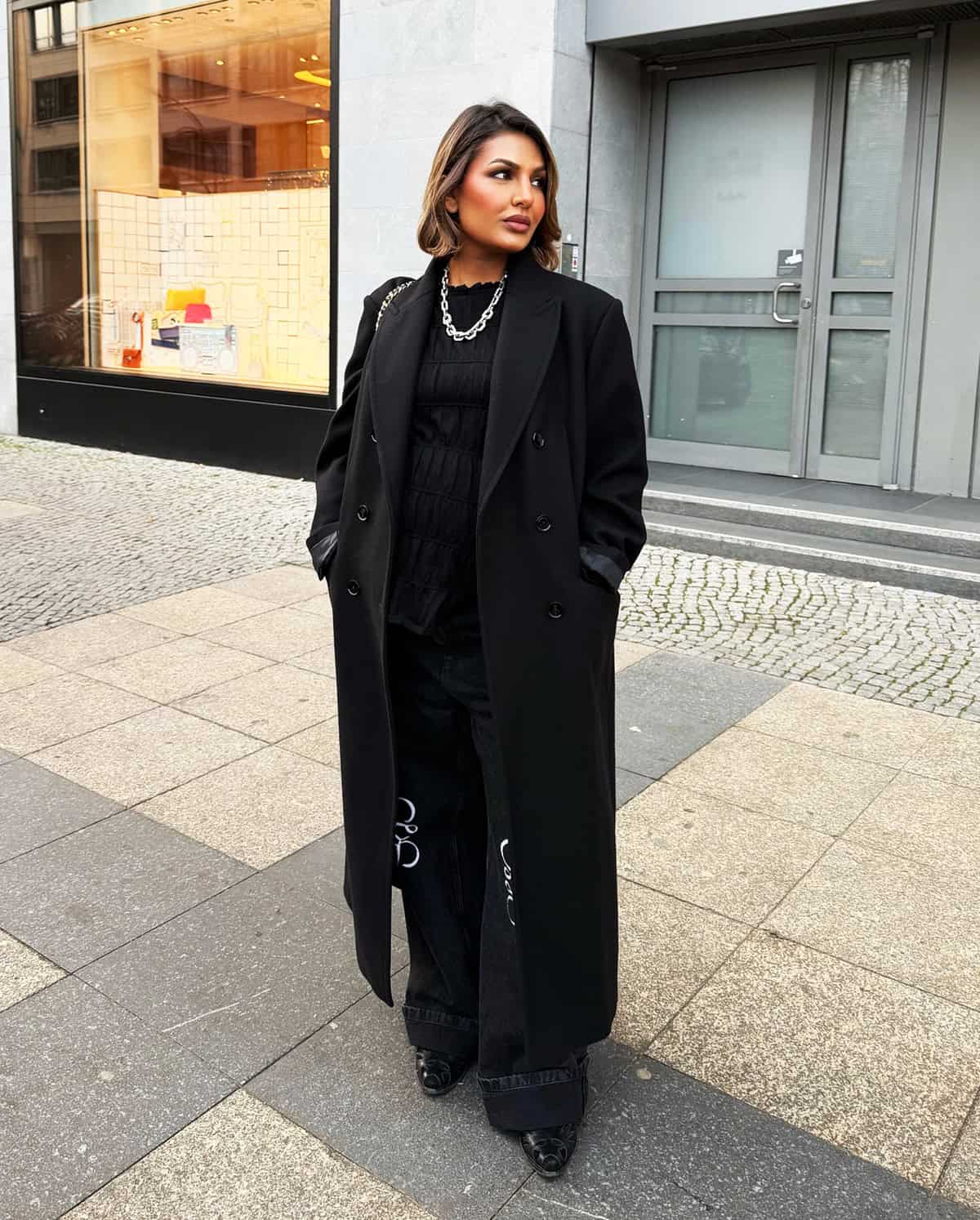 all-black outfit layered with long structured coat and wide-leg trousers classy outfits for date night