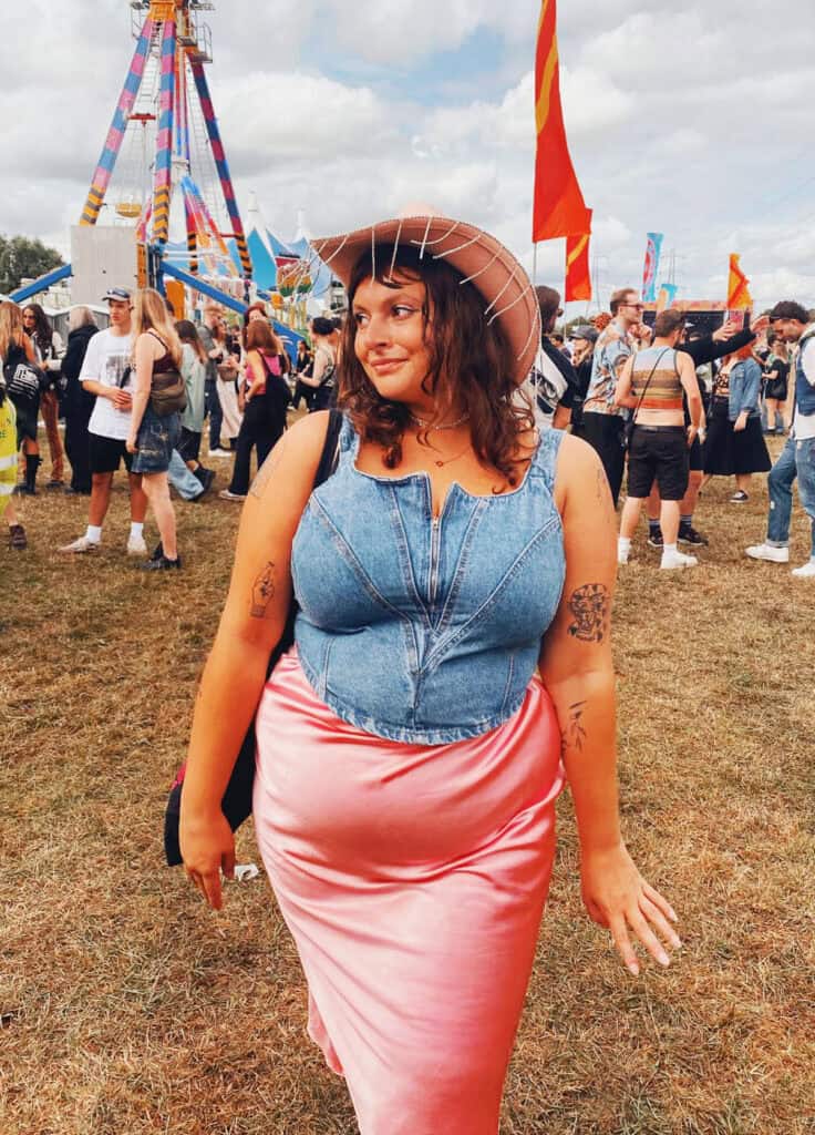 denim corset top and pink satin midi skirt with cowboy hat for festival outfits for plus size women