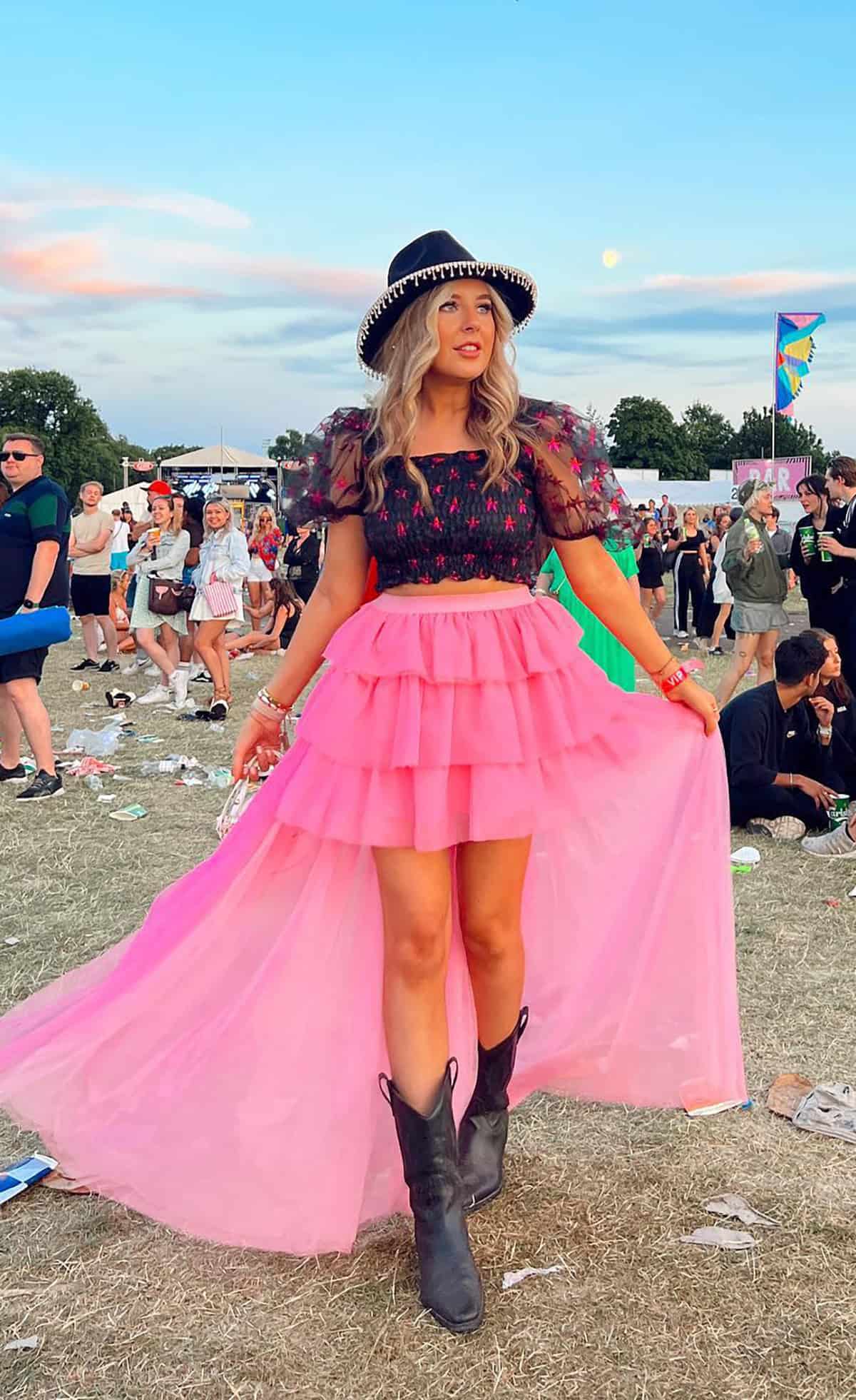 pink layered skirt with black top and cowboy boots outfit ideas for music festival