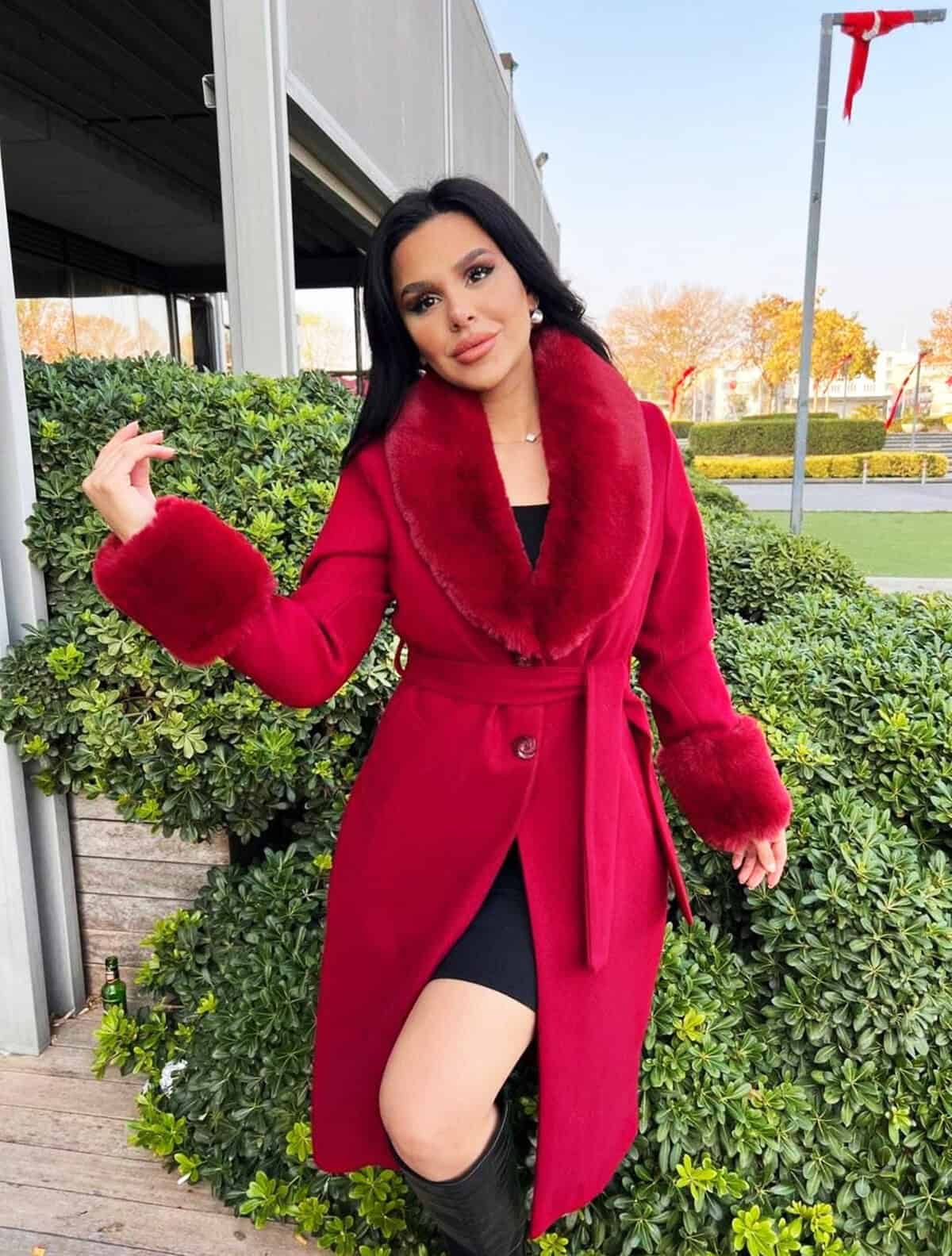 red winter coat with faux fur collar layered over a cocktail dress for a winter cocktail outfit