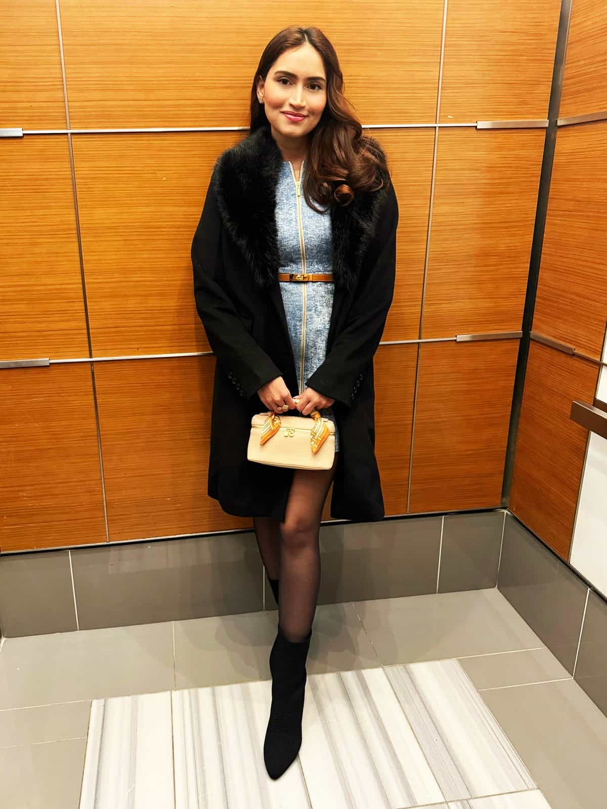 dressy winter coat layered over a cocktail dress with tights and ankle boots for a winter cocktail outfit