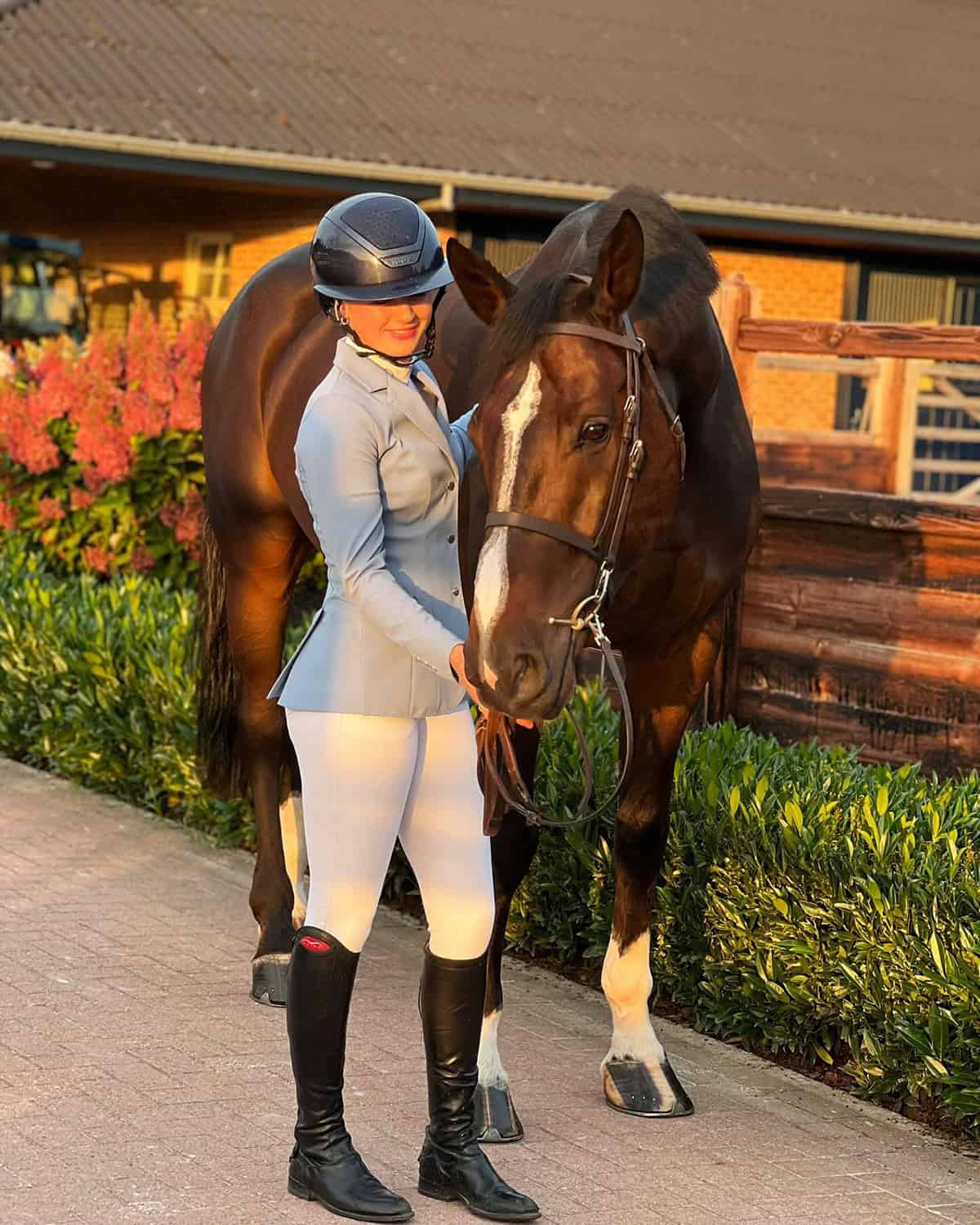 rider in light gray riding jacket with white breeches, helmet, and tall boots for a modern polished look, Best equestrian outfits for English riding