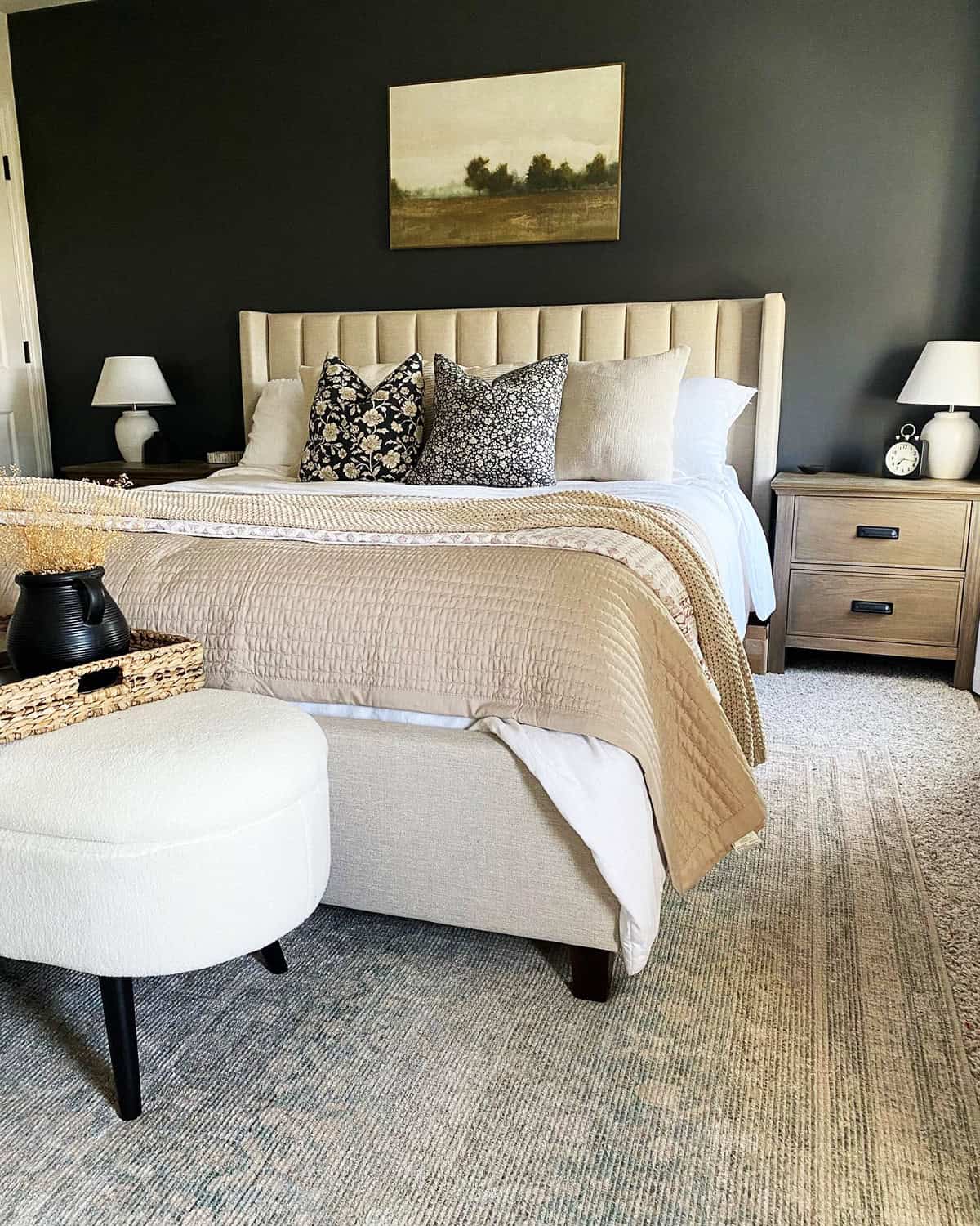 neutral quilted bedding with knit throw and floral pillows against dark wall cottagecore bedroom insp