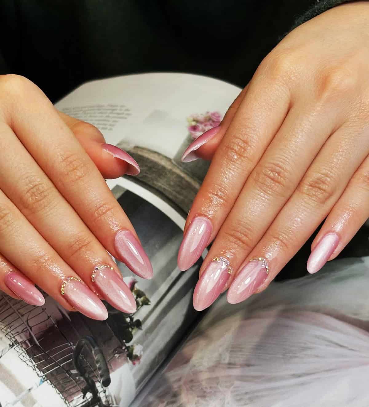 soft pink chrome almond nails with rhinestone accents glossy glazed finish pink chrome nails
