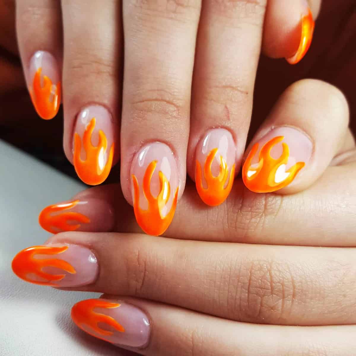 almond nails with neon orange flame nail art on sheer clear base fire nails