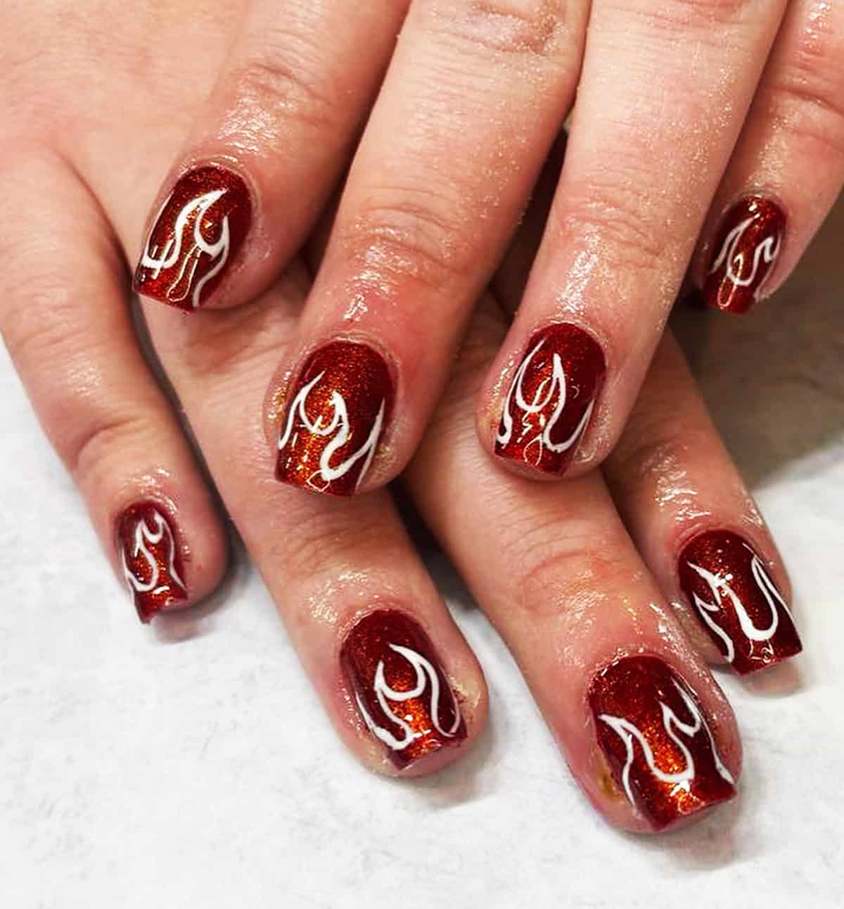 short square nails with dark red glitter base and white flame nail art fire nails