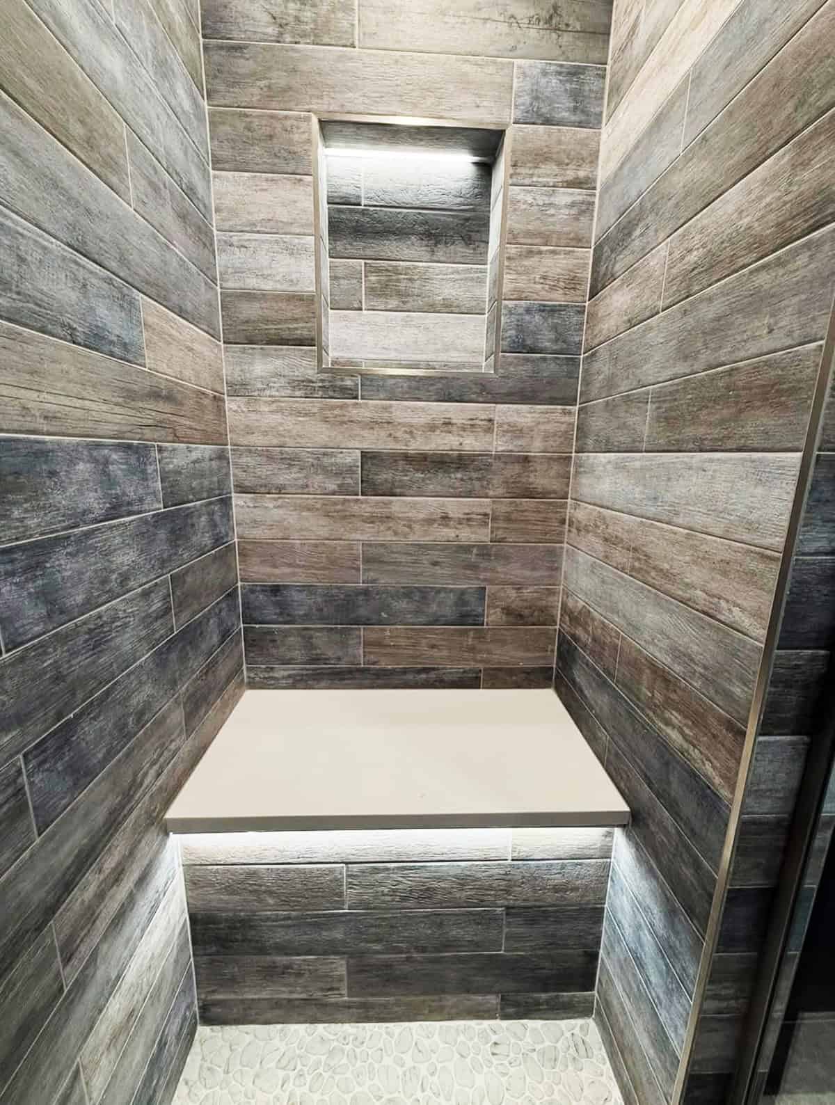 wood look tile shower with bench and pebble floor bathroom tile ideas