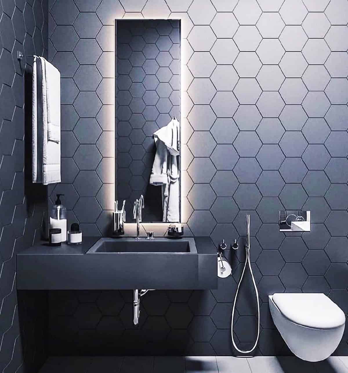 black hexagon wall tiles in modern bathroom with floating sink and backlit mirror black bathroom ideas