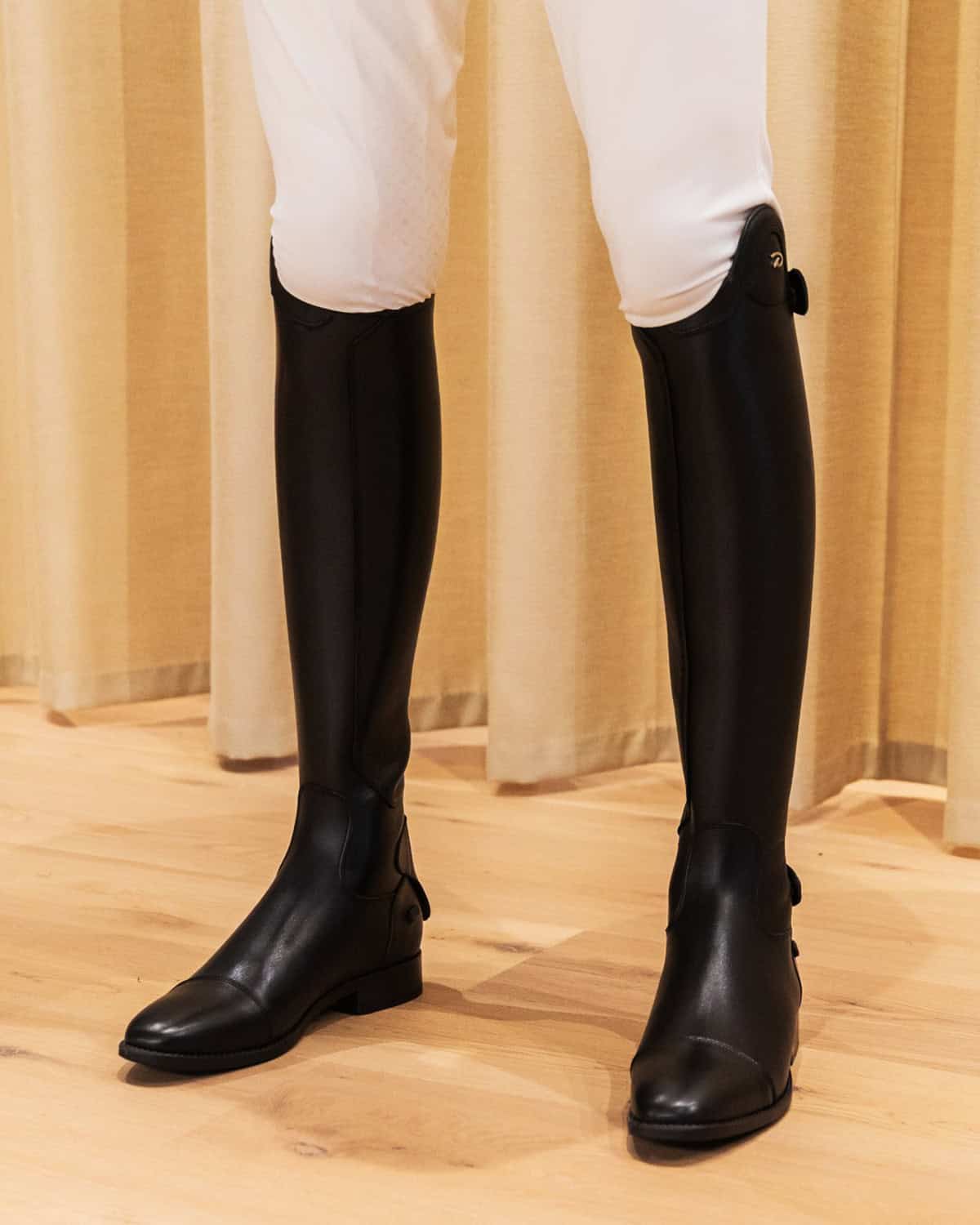 sleek black tall riding boots worn with white breeches for classic English riding look, Best equestrian outfits for English riding