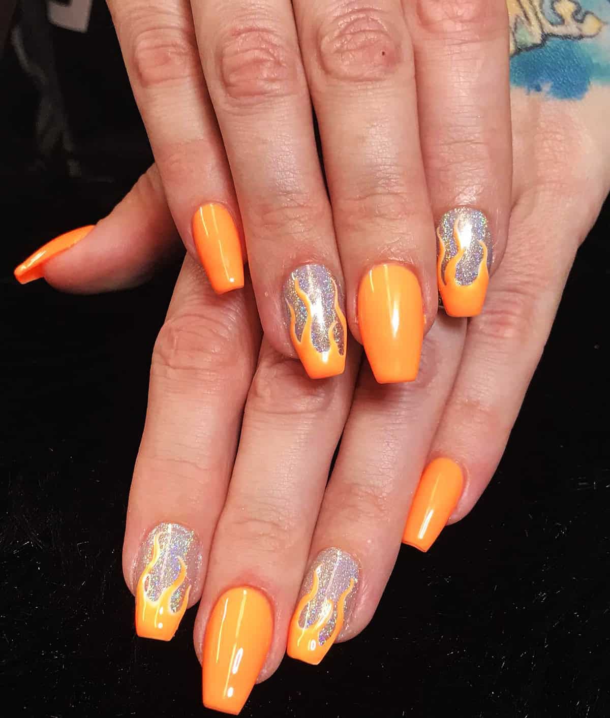 neon orange coffin nails with holographic silver glitter accent nails and orange flame art fire nails