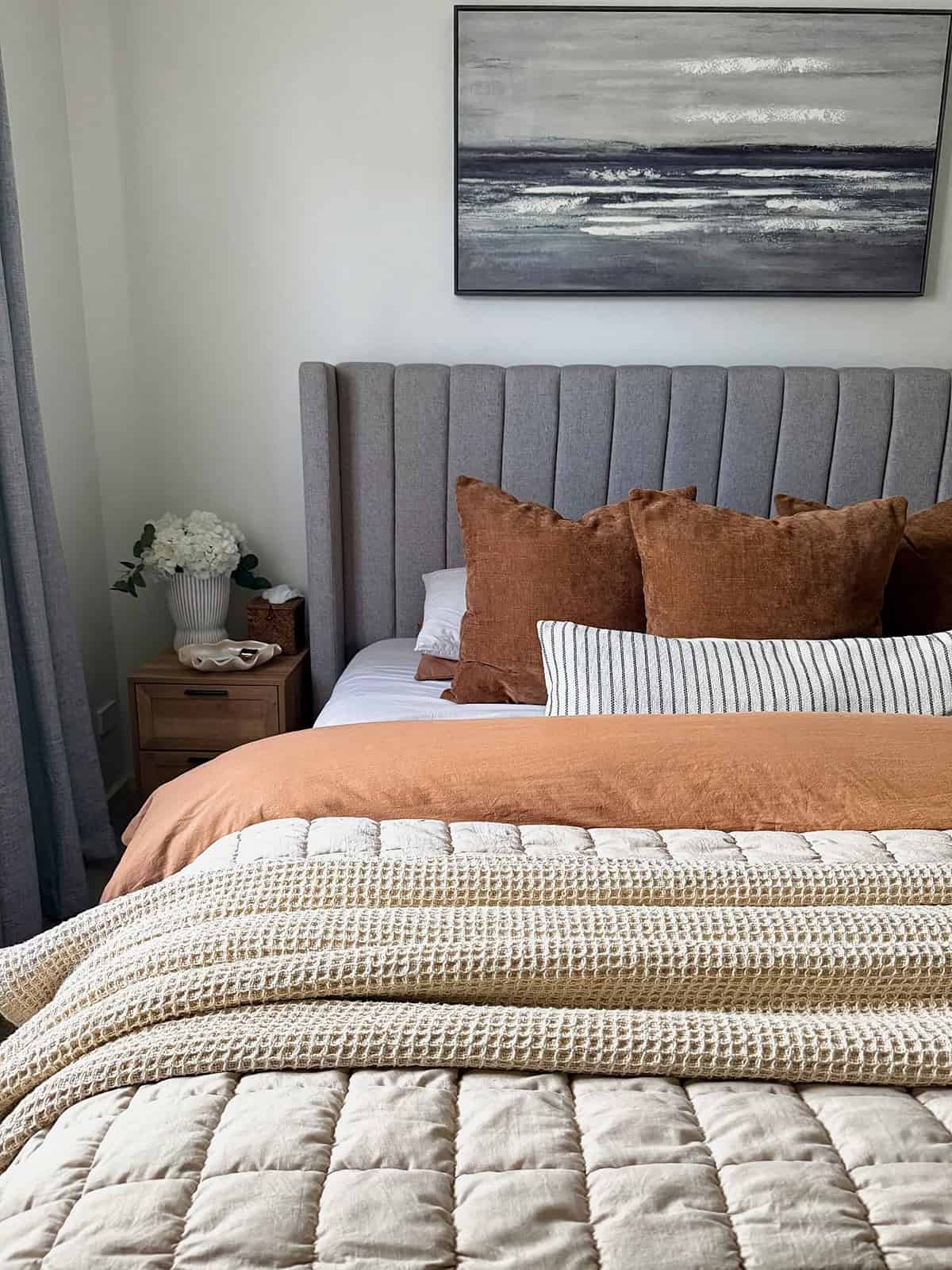 soft rust and cream bedding with textured layers and simple wood nightstand cottagecore bedroom insp