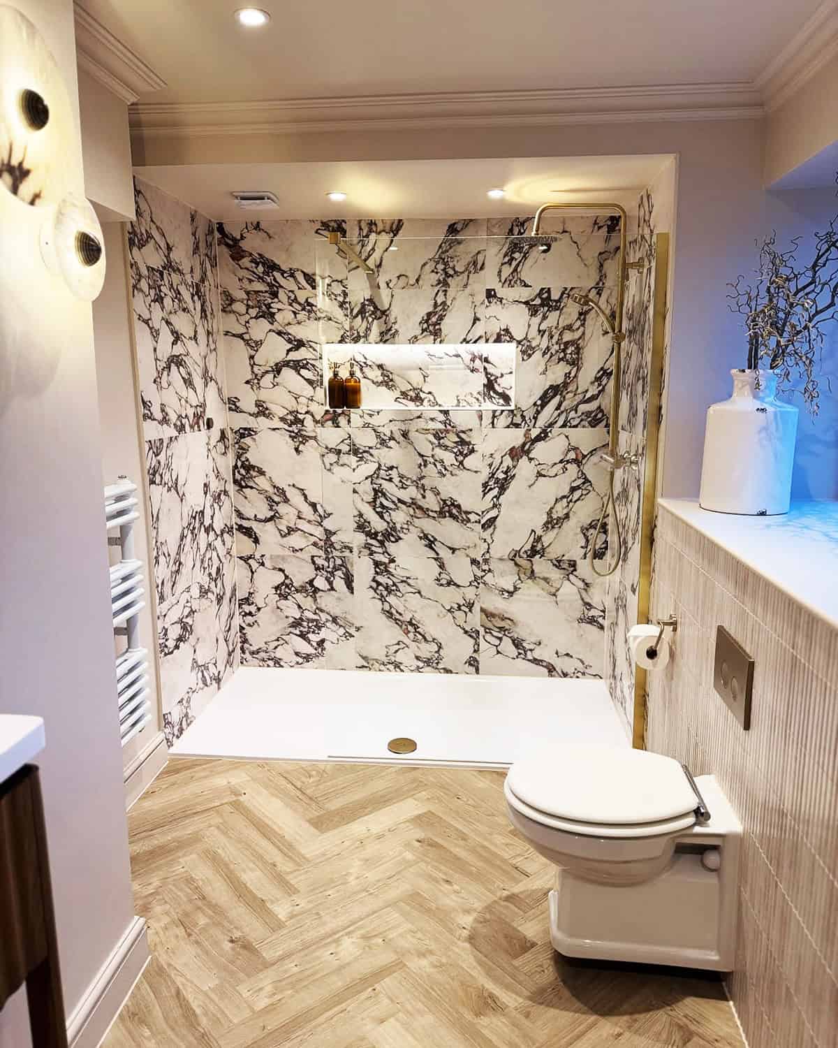 bold veined marble shower wall with herringbone wood floor tile ideas