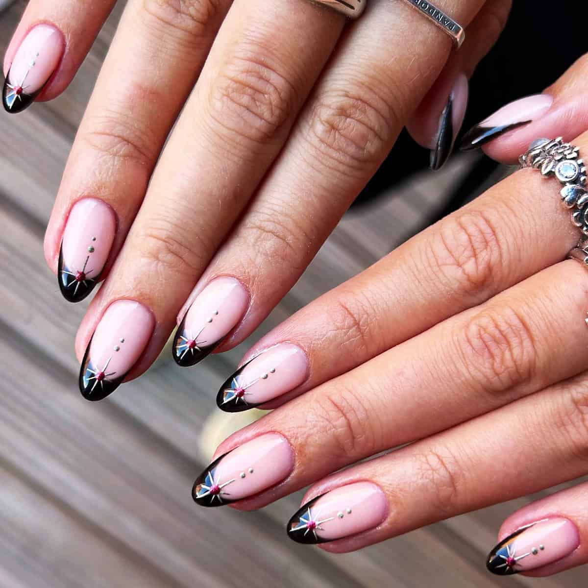 ude almond nails with black chrome tips and star gem accents black chrome nails