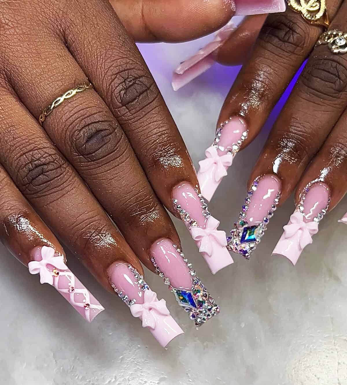 pink glossy nails with rhinestones and bow details glam baddie nails for summer