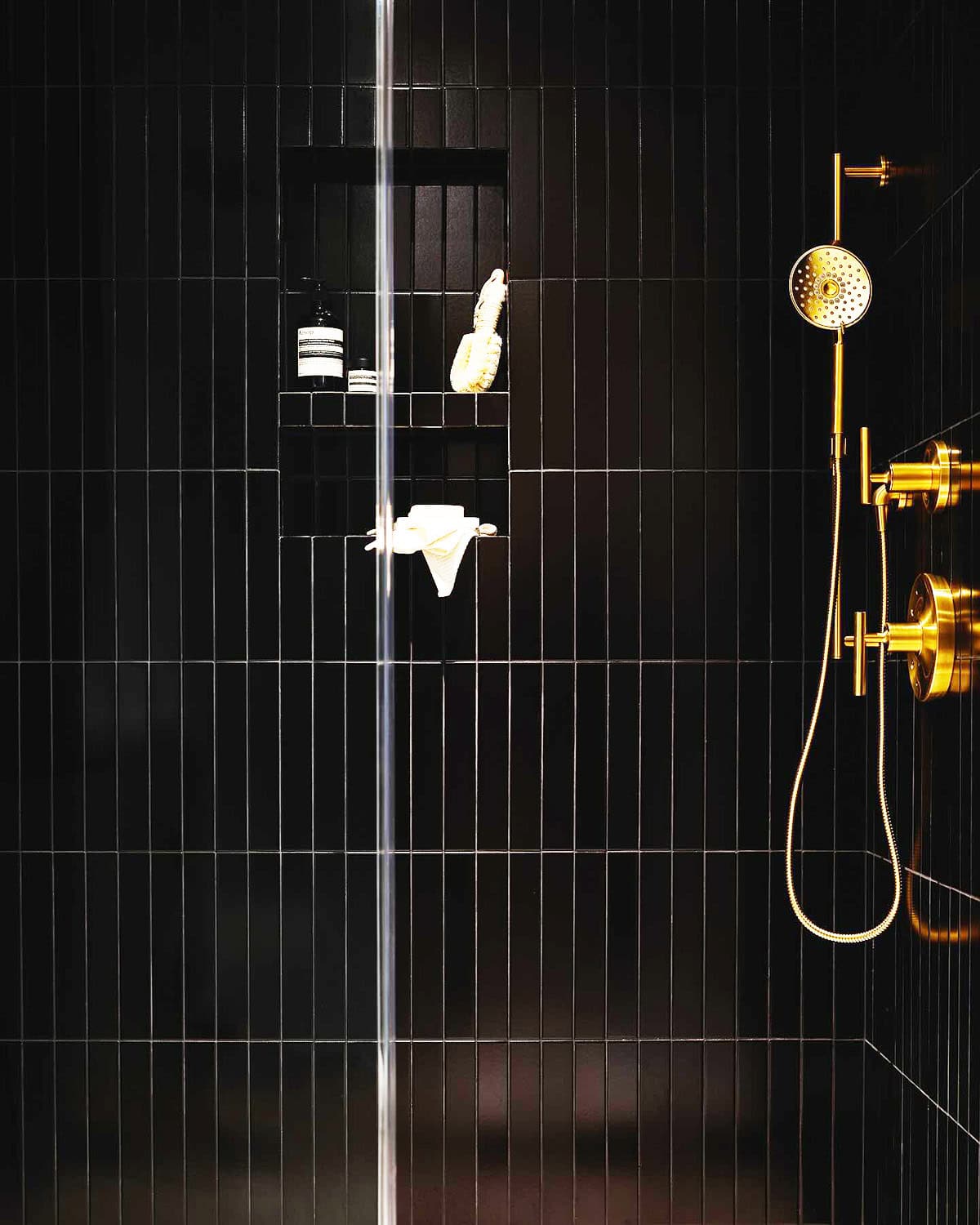 vertical black shower wall tiles with gold fixtures modern bathroom tile design black bathroom ideas