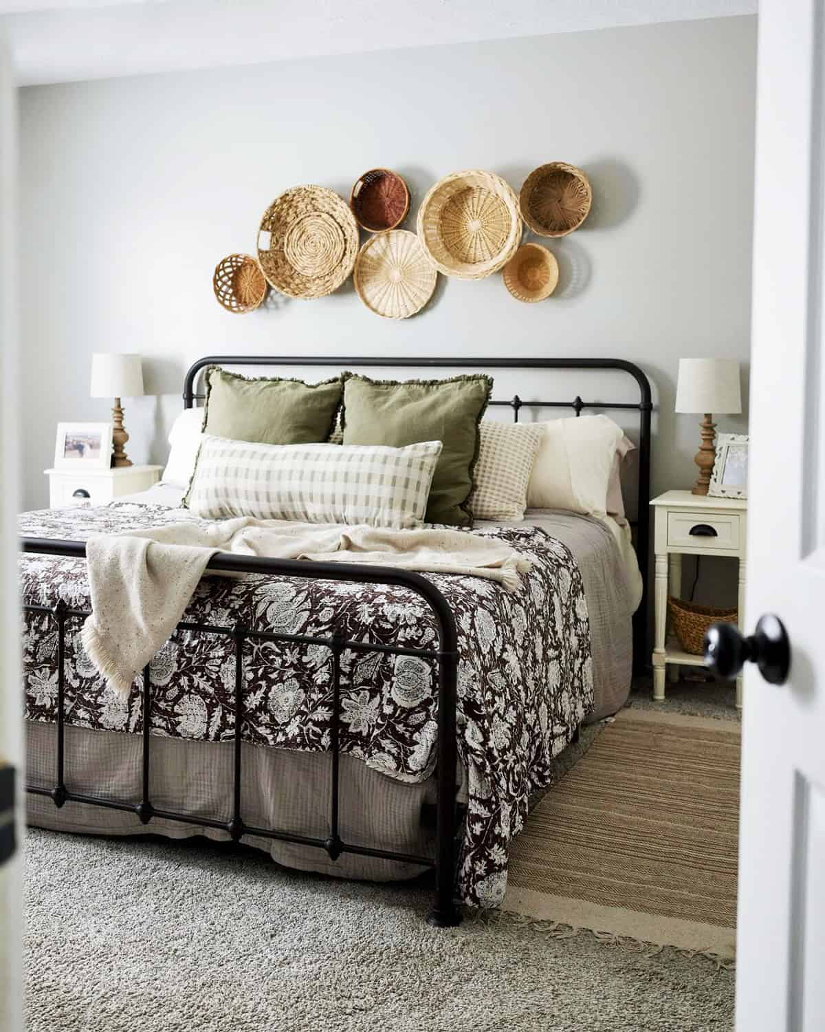 metal bed frame with mixed bedding patterns and woven wall decor, casual cozy bedroom cottagecore bedroom insp
