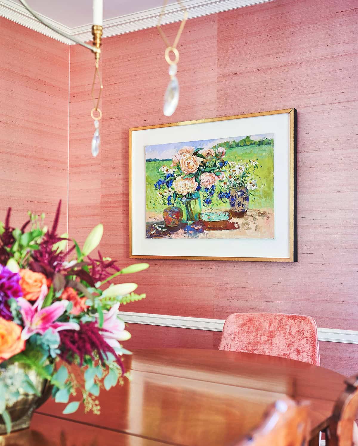pink grasscloth textured wallpaper in a warm dining room with oil painting and fresh flowers pink wallpaper ideas home decor
