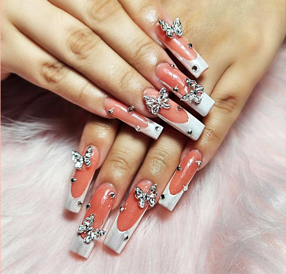 glossy pink square nails with butterfly charms and rhinestone accents baddie nails for summer