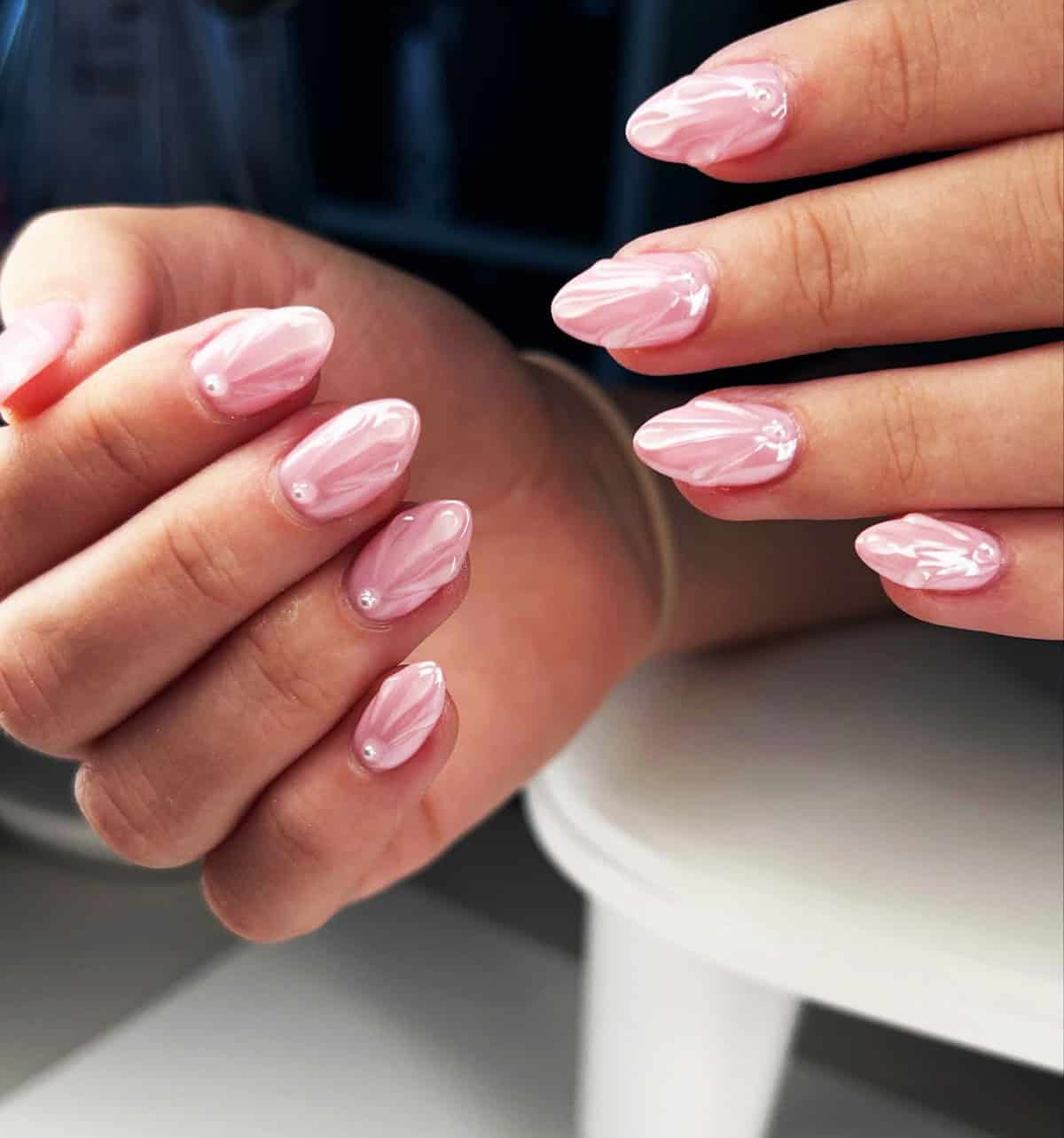 pearly pink chrome almond nails with swirl designs and gem accents soft luminous finish pink chrome nails