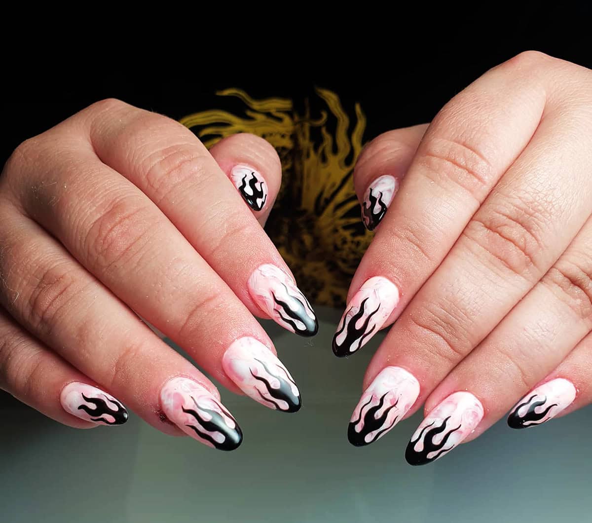 almond nails with pink watercolor base and black flame tip nail art fire nails