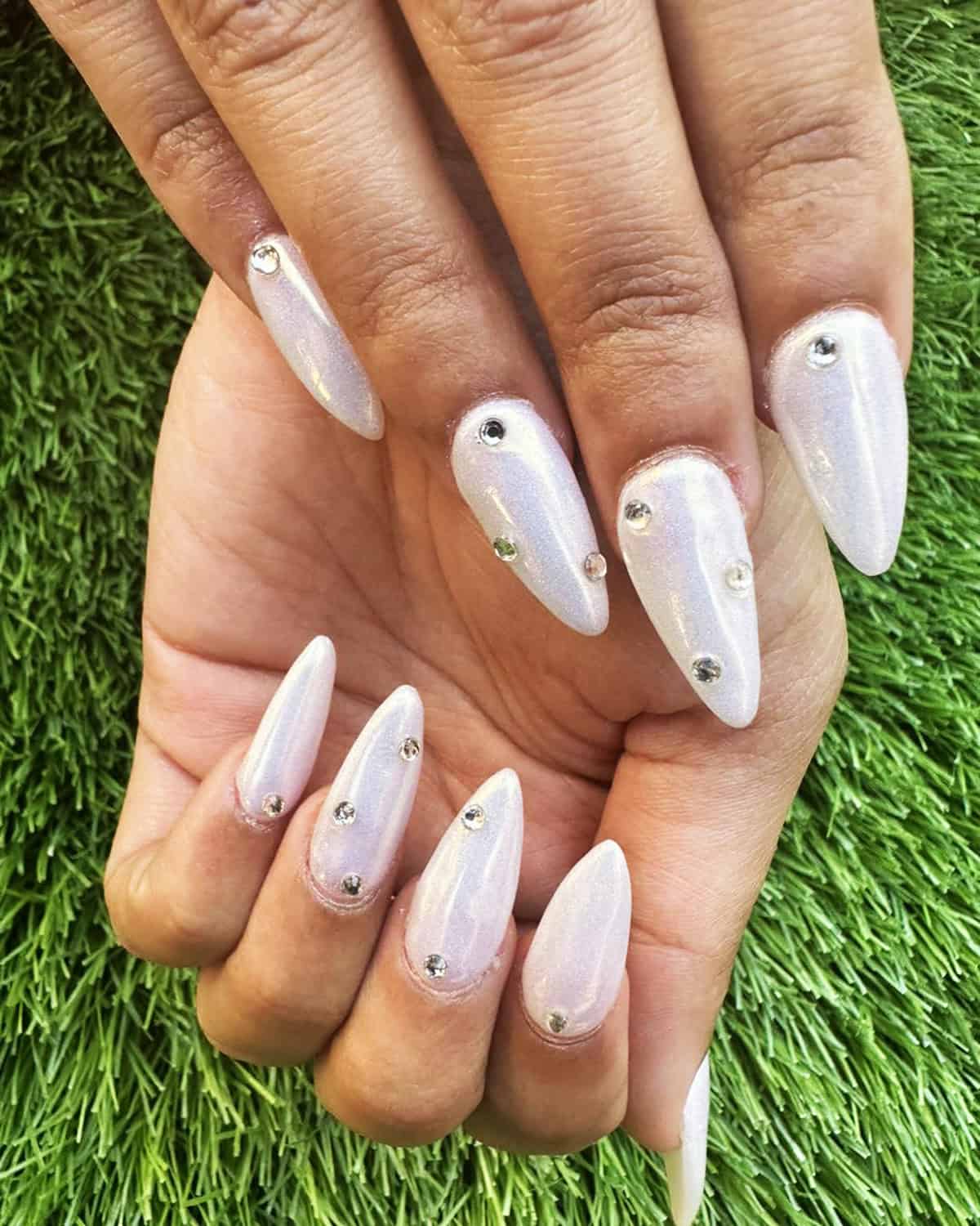 iridescent white chrome almond nails with crystal rhinestone accents white chrome nails