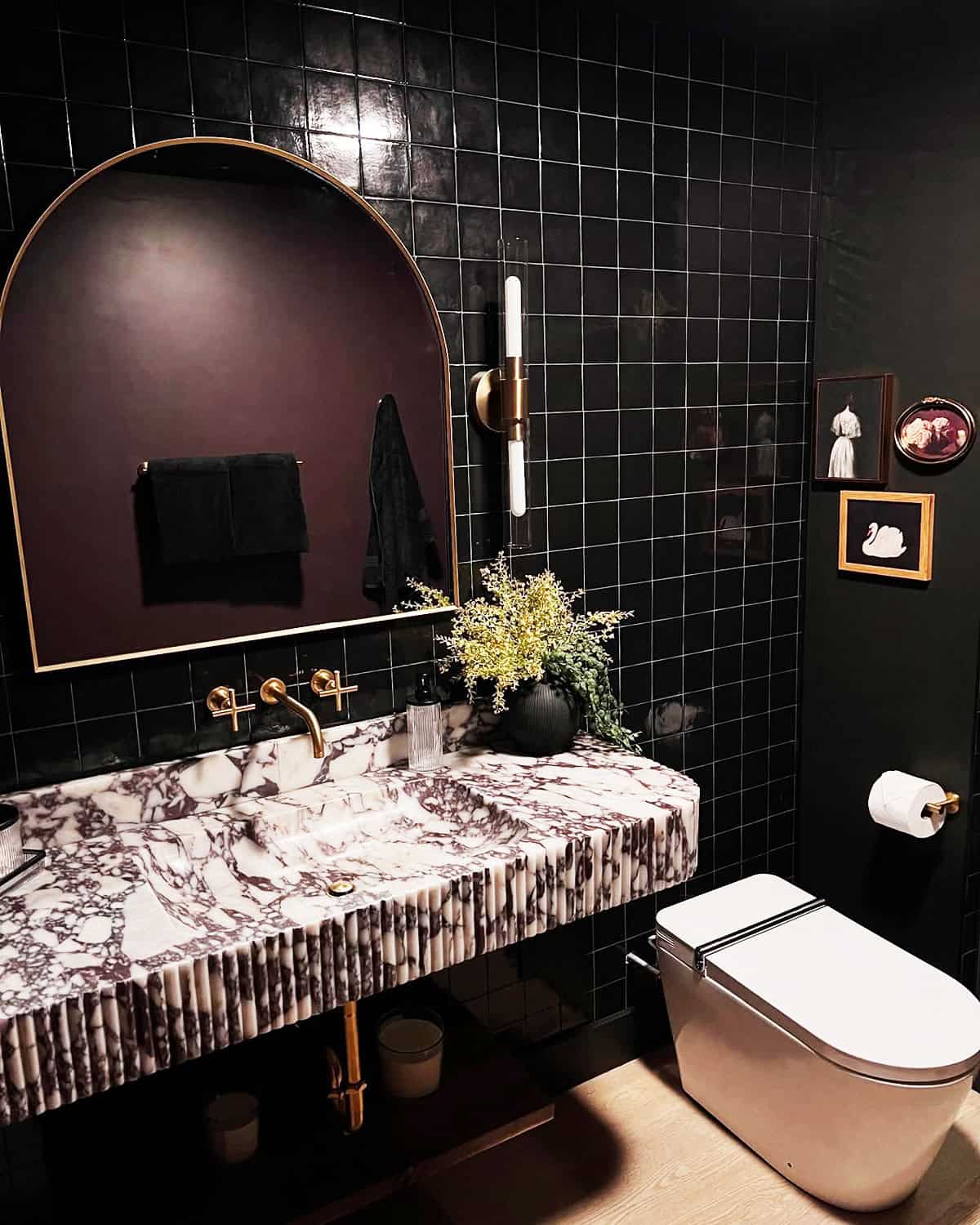 black tiled bathroom with marble sink and brass fixtures black bathroom ideas