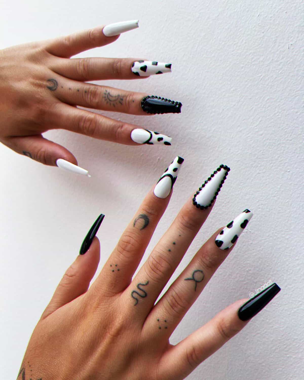 mixed black and white coffin nails with cow print and solid color designs, trendy black baddie nails