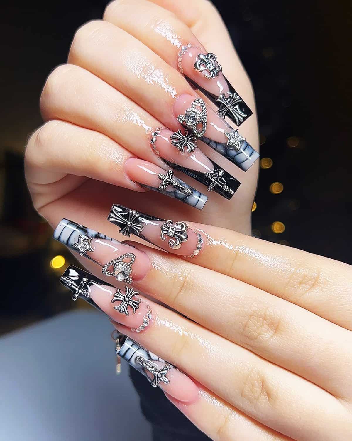 long coffin nails with clear and smoky black designs layered with silver charms and crystals black baddie nails