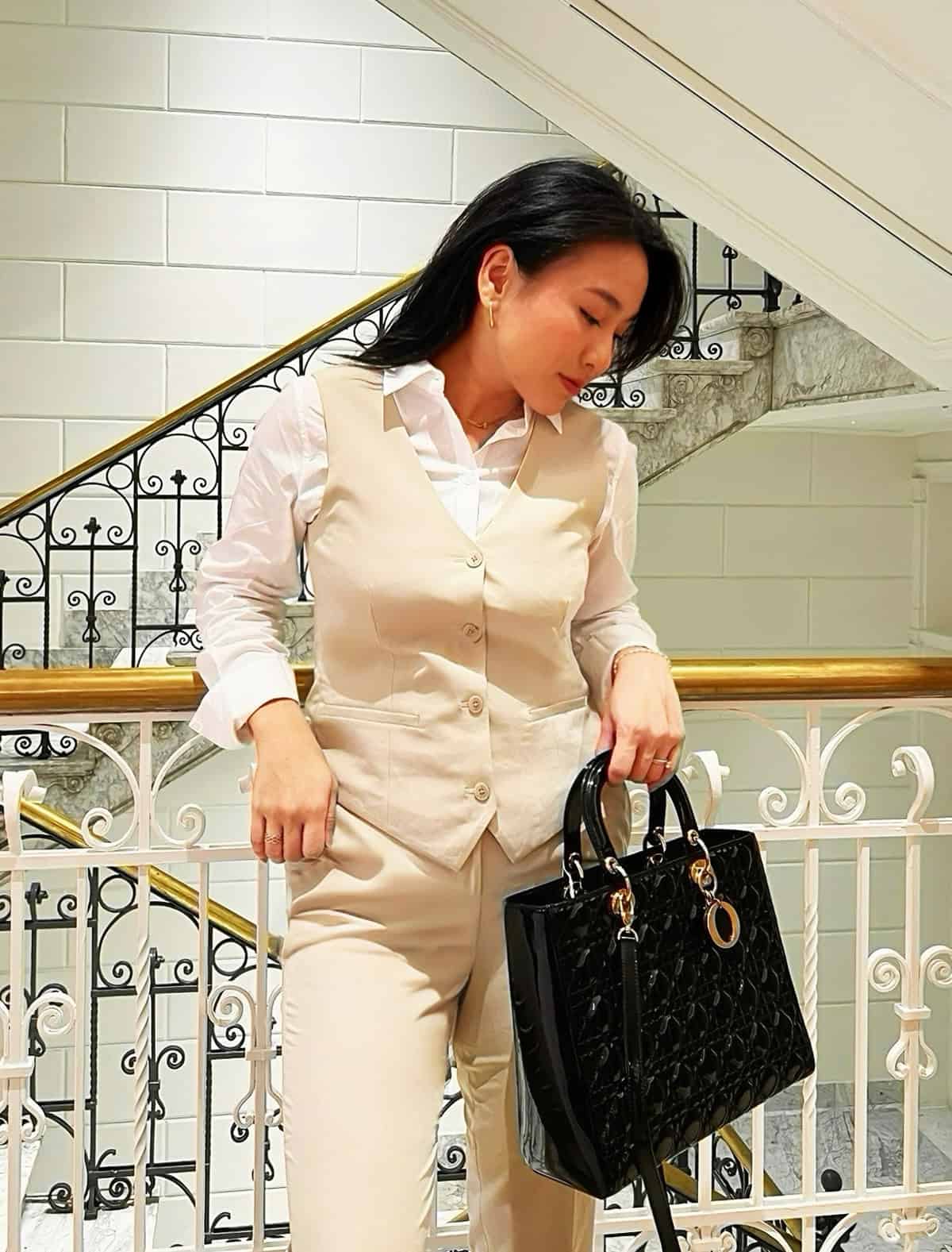 white button-down shirt under fitted beige vest with matching tailored trousers for office attire for women over 40