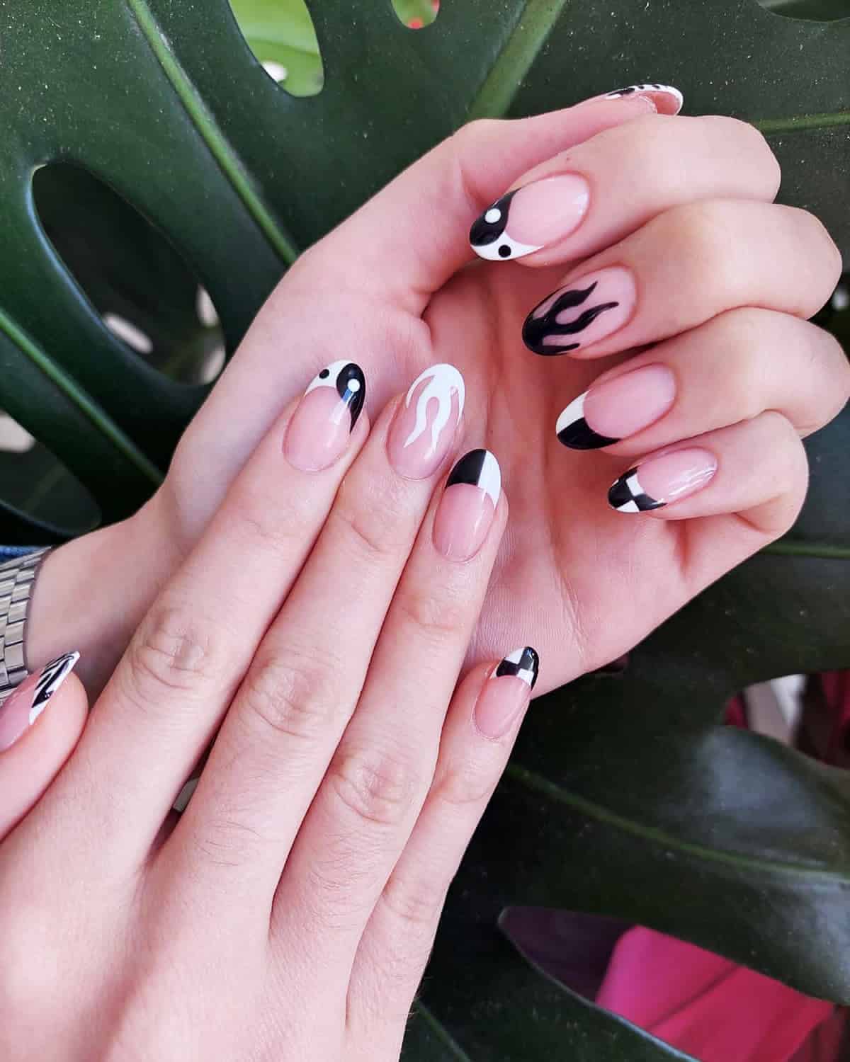almond nails with mixed black and white nail art including flame tips yin yang and half moon fire nails