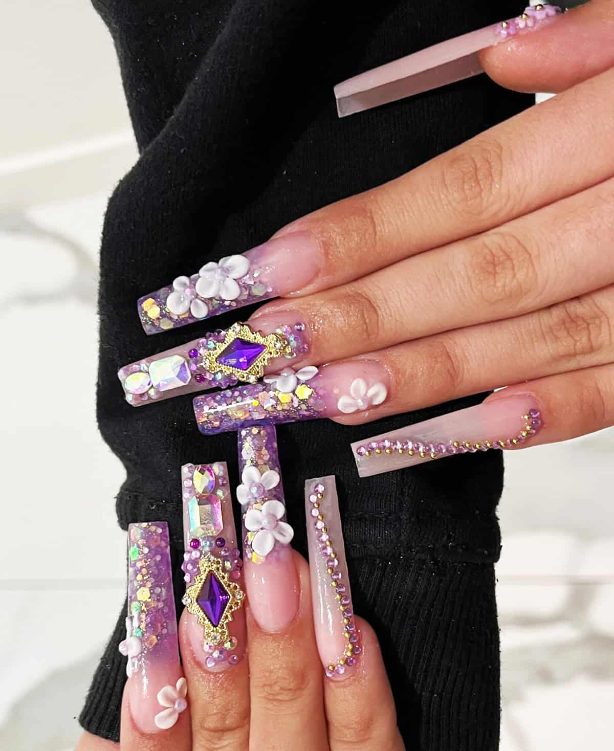purple glitter nails with chunky gems and 3D floral details statement glam baddie nails for summer