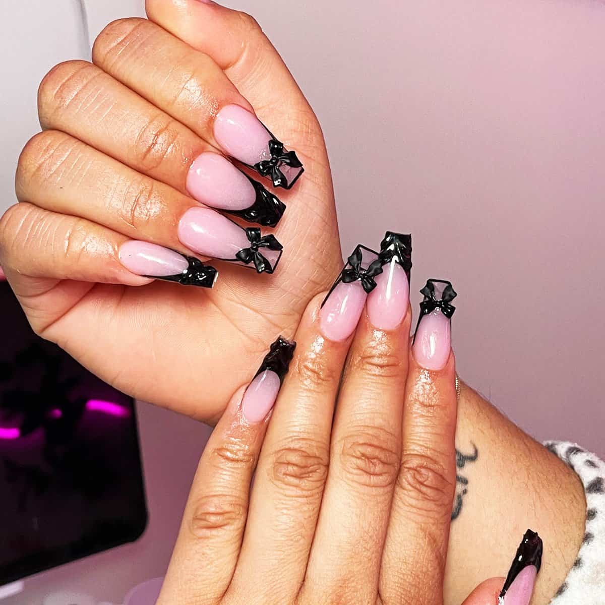 pink almond nails with glossy black tips and 3D bow details, cute soft black baddie nails