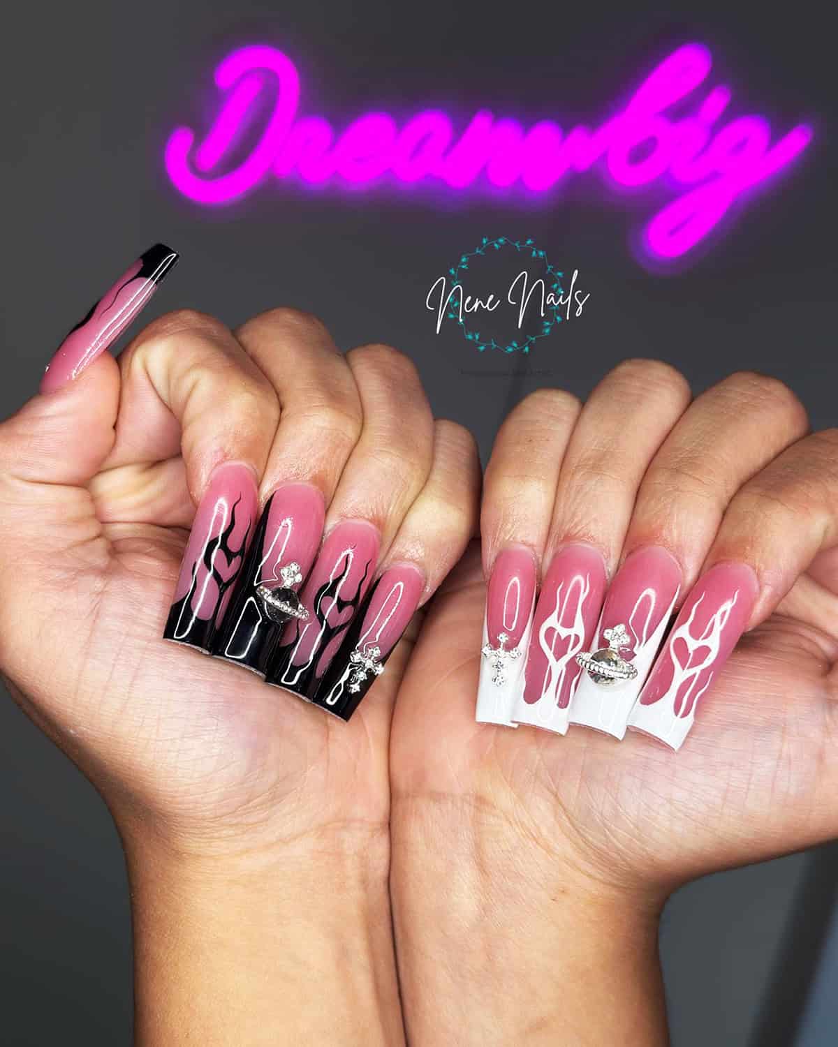 long coffin nails in pink and black flame designs with rhinestone charm details fire nails