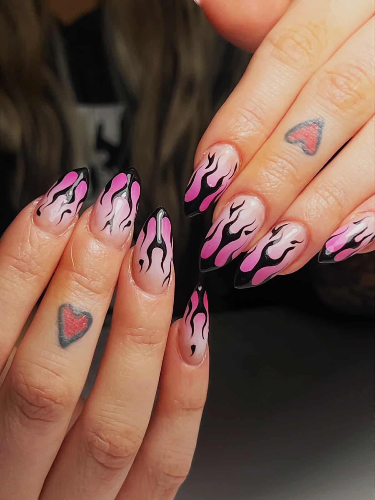 long stiletto nails with pink and black outlined flame nail art on nude base fire nails