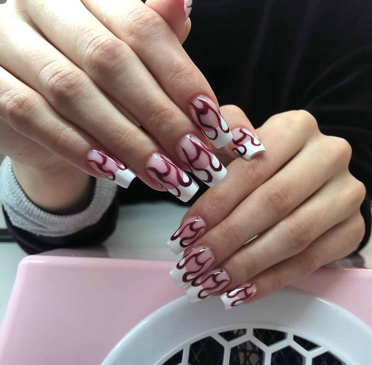 Long square white nails with dark burgundy hand-drawn flame nail art fire nails