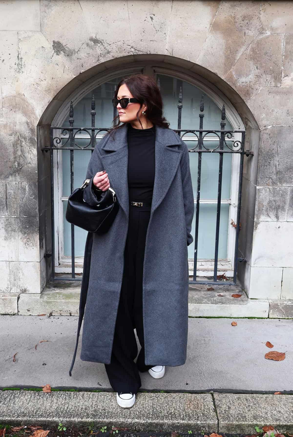 all black outfit with oversized grey wool coat, wide-leg trousers and white sneakers for office attire for women over 40