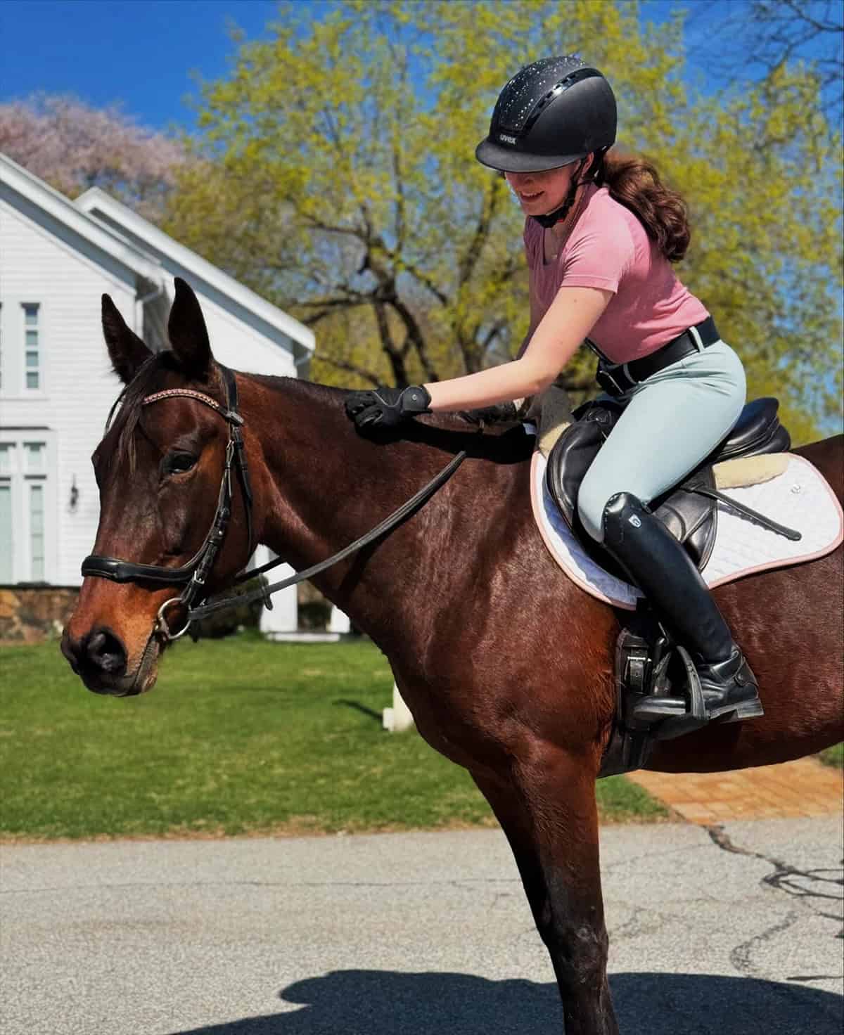 pink fitted top with light breeches, helmet, gloves, and tall boots for casual riding, best equestrian outfits for English riding