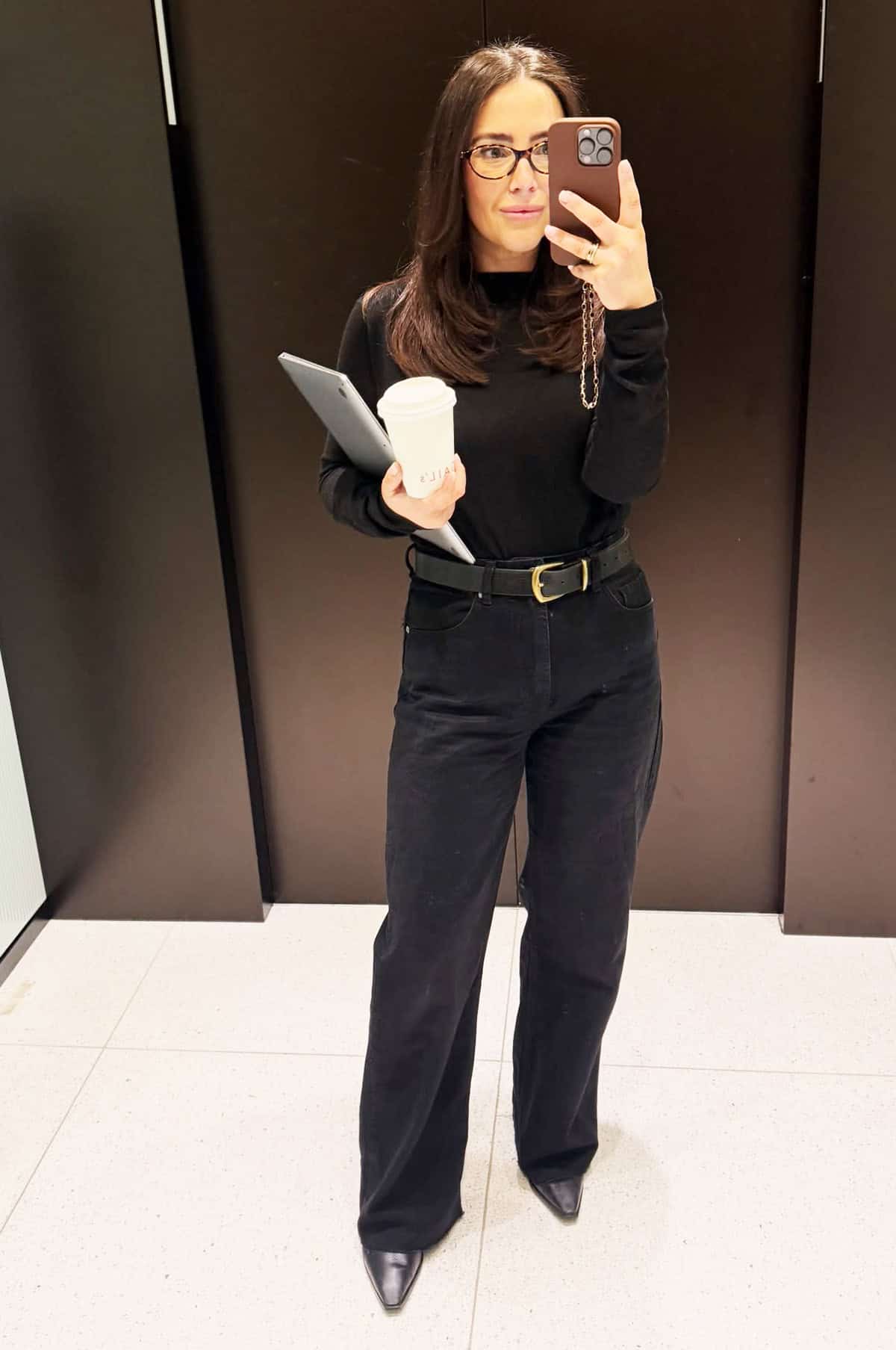 all black mock-neck top with wide-leg trousers, gold belt and pointed boots for office attire for women over 40
