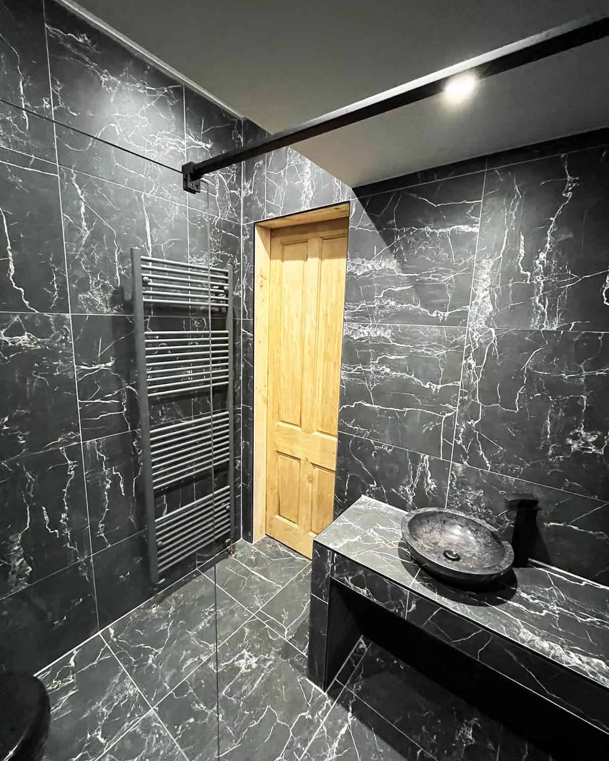 full black marble tile bathroom with wood accents black bathroom ideas