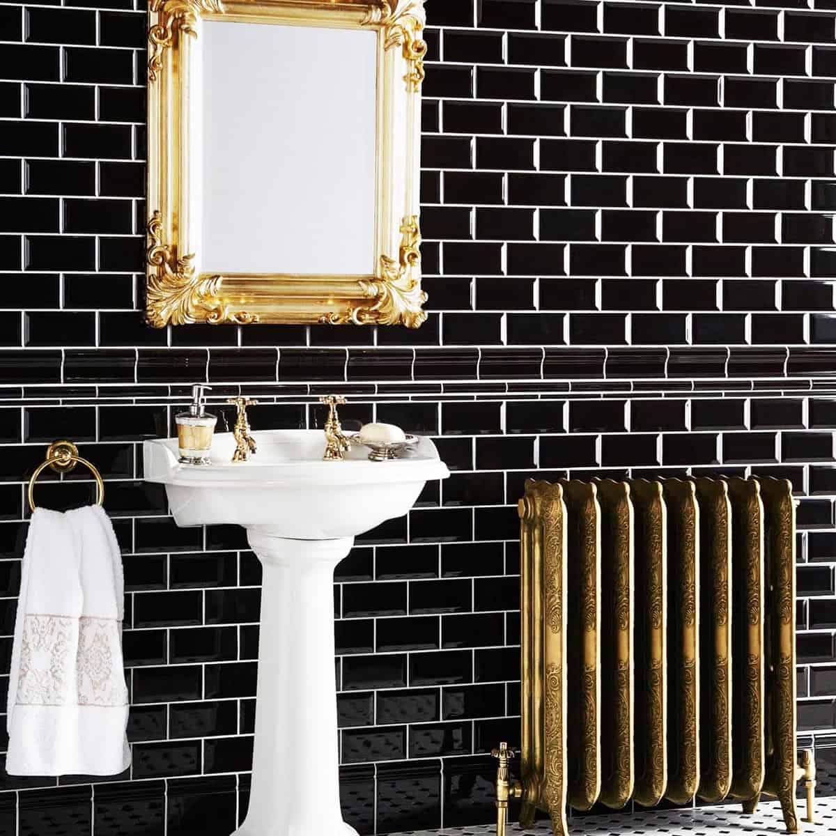 glossy black subway wall tiles with white pedestal sink and gold accents vintage style bathroom black bathroom ideas
