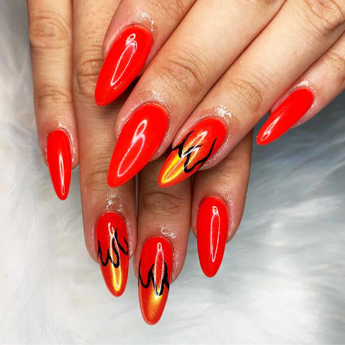 red-orange almond nails with orange gold flame accent nails and black outlines fire nails