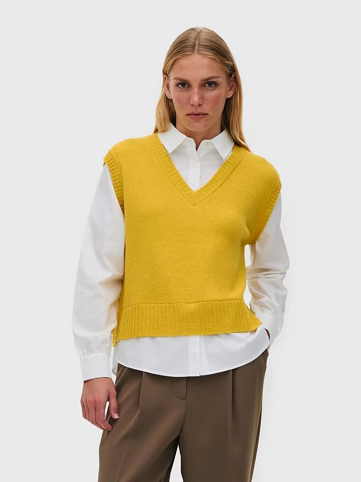 light sweater vest layered over a button-down shirt