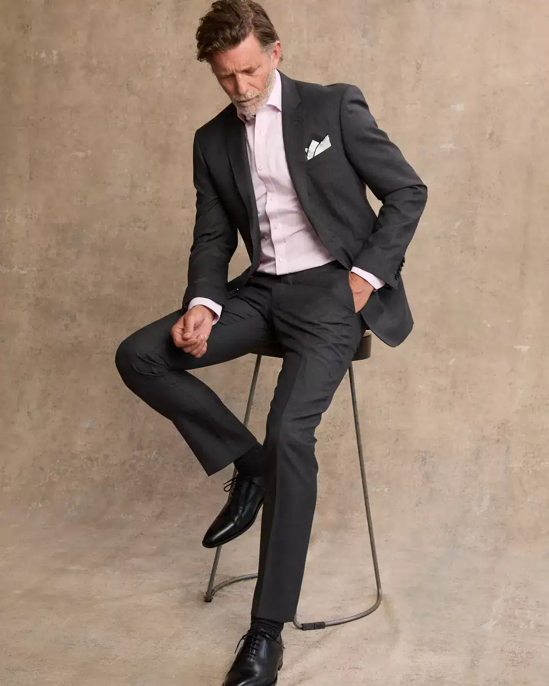 man in charcoal suit with pastel shirt