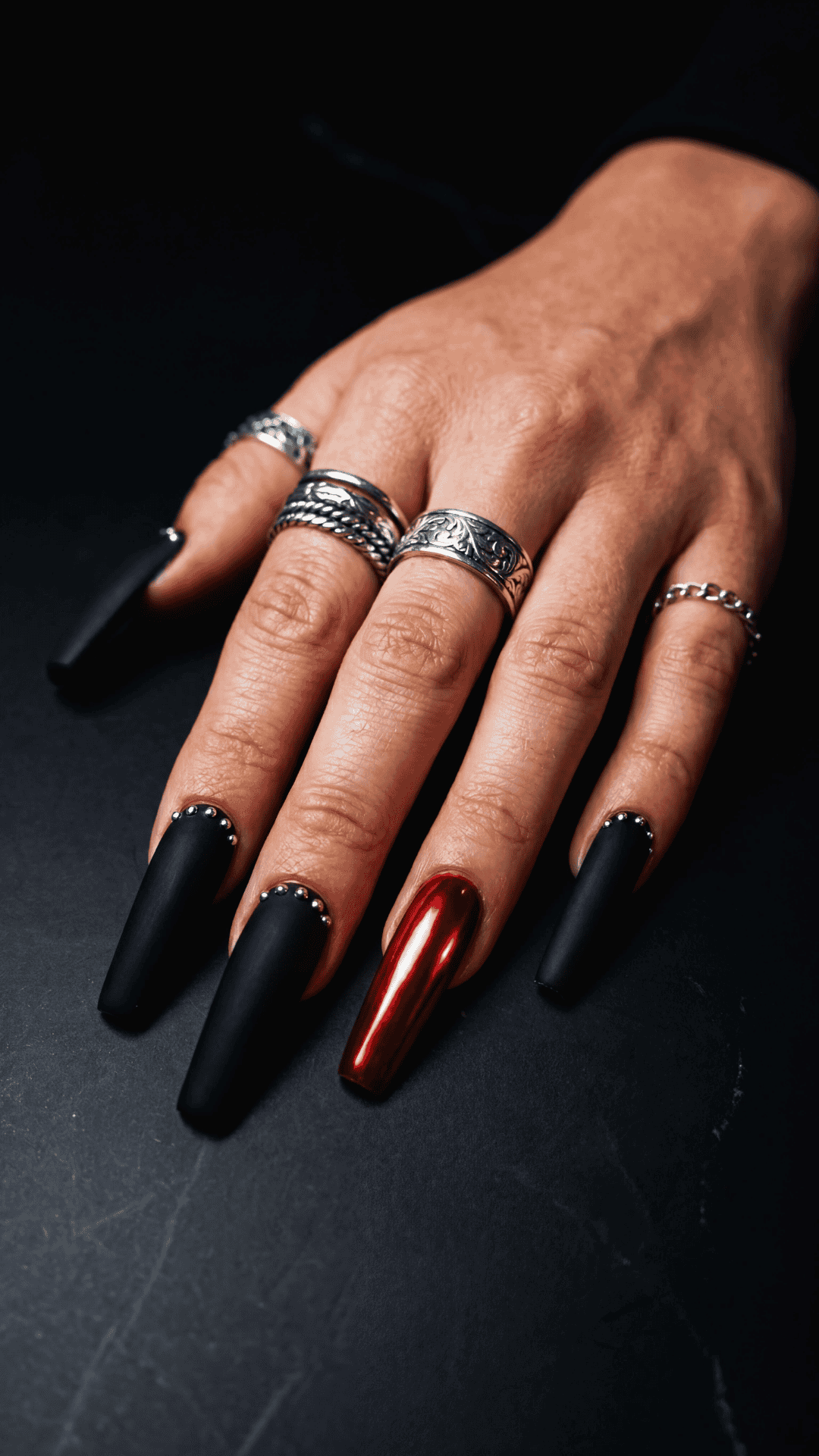 matte black nails with one red accent nail