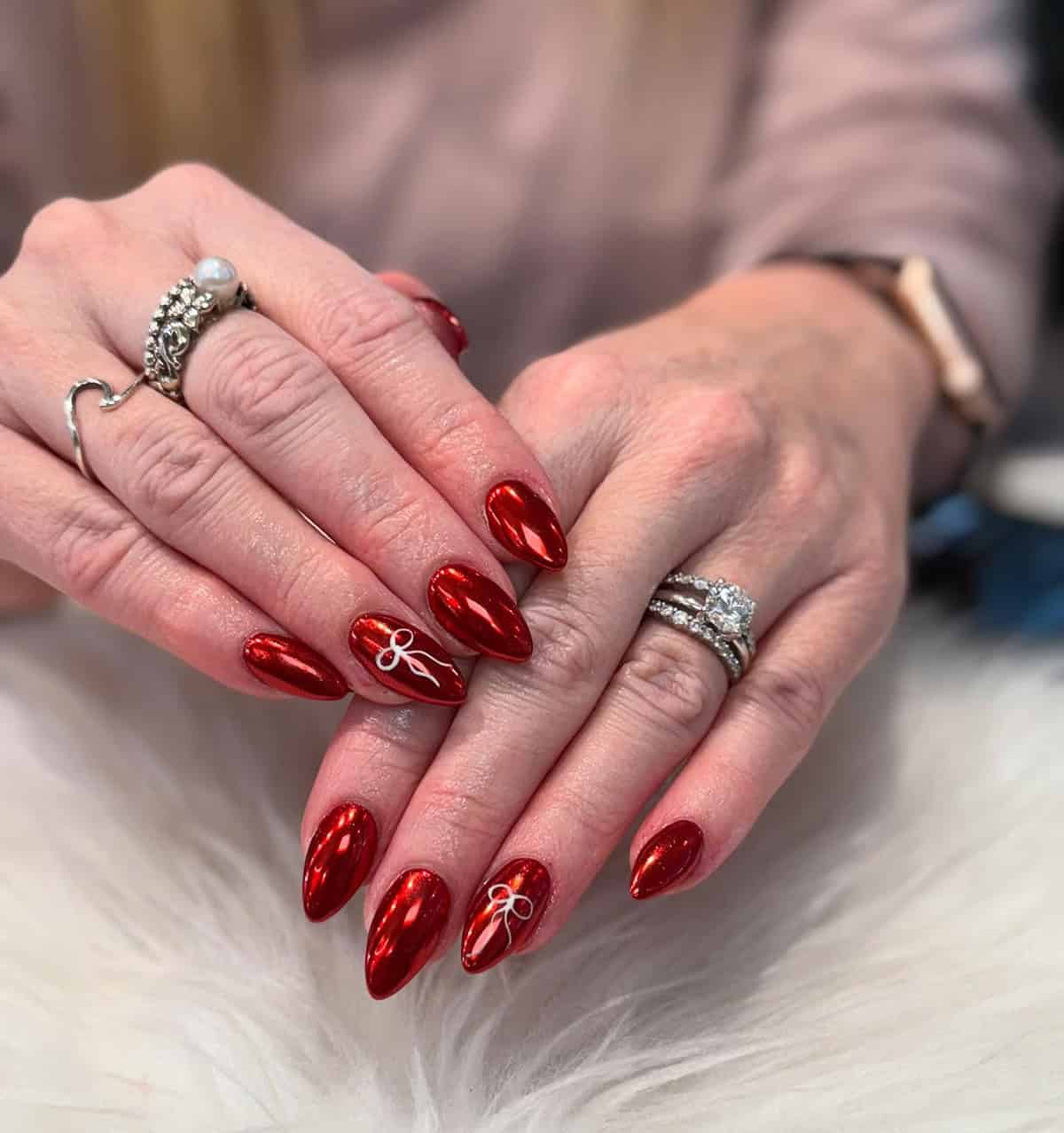 almond red chrome nails with tiny white bow accent simple chic design red chrome nails