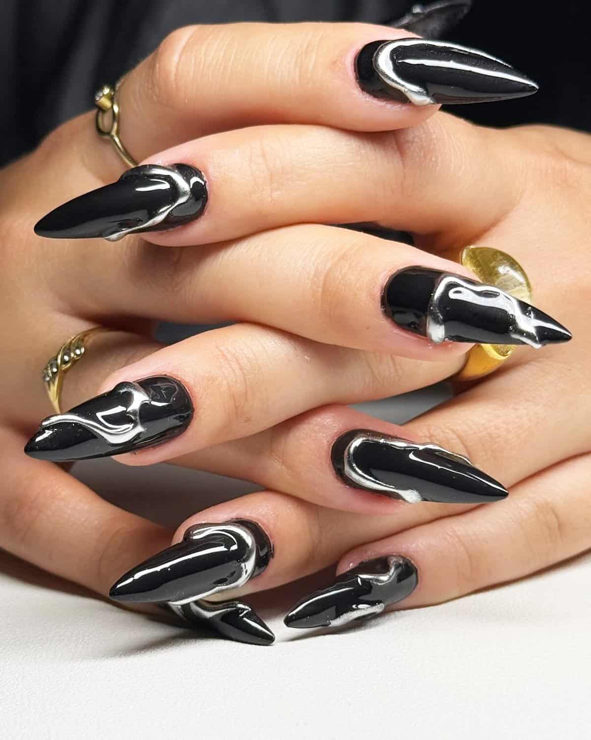 black stiletto nails with silver chrome drip effect, edgy artistic black baddie nails