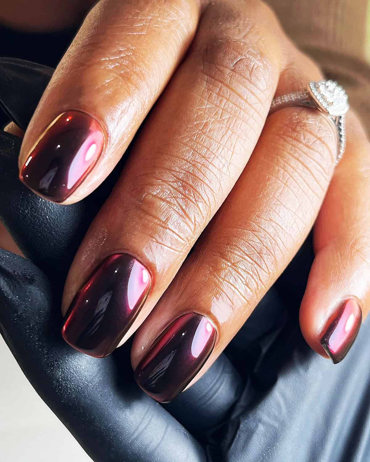 short nails with red toned black chrome reflective finish black chrome nails