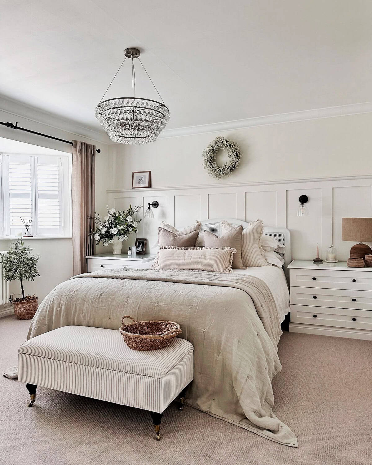 neutral layered bedding with striped pillows, chandelier, airy spacious bedroom cottagecore bedroom insp