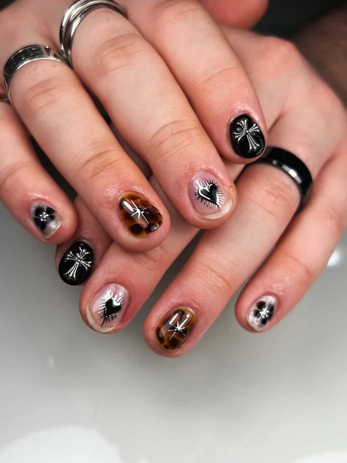 short nails with black chrome, charms, and mixed art designs black chrome nails