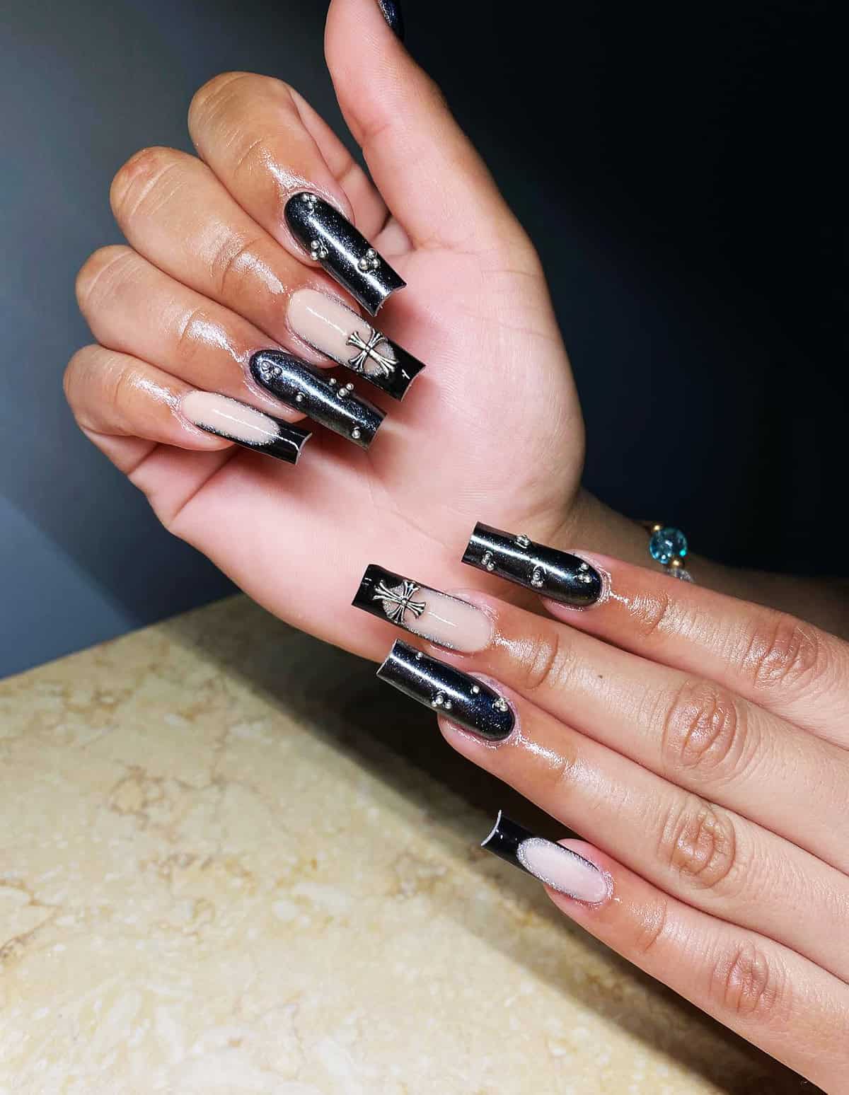 long square nails with black chrome shimmer and metallic charm details black chrome nails